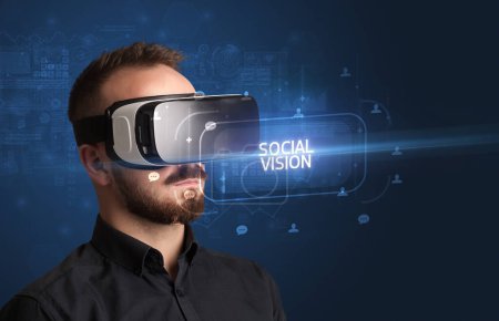 Photo for Businessman looking through Virtual Reality glasses with SOCIAL VISION inscription, social networking concept - Royalty Free Image