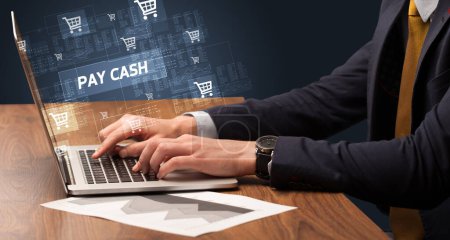 Téléchargez les photos : Homme d'affaires travaillant sur ordinateur portable avec inscription PAY CASH, concept d'achat en ligne - en image libre de droit