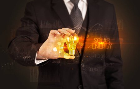 Foto de Empresario portador de bombilla con inscripción SOLAR ENERGY, Concepto de tecnología empresarial - Imagen libre de derechos
