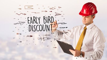 Photo for Handsome businessman with helmet drawing EARLY BIRD DISCOUNT inscription, contruction sale concept - Royalty Free Image