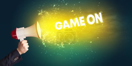 Photo for Young woman yelling to loudspeaker with GAME ON inscription, modern media concept - Royalty Free Image