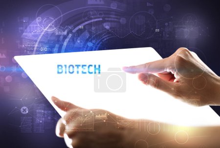 Téléchargez les photos : Tablette futuriste Hand Holdig avec inscription BIOTECH, nouveau concept technologique - en image libre de droit