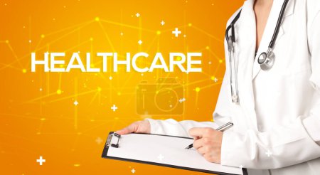 Photo for Doctor fills out medical record with HEALTHCARE inscription, medical concept - Royalty Free Image
