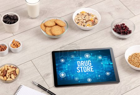 Téléchargez les photos : Concept DRUG STORE en comprimé PC avec des aliments sains autour, vue du dessus - en image libre de droit