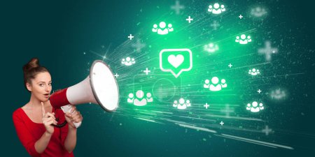 Téléchargez les photos : Jeune crier dans haut-parleur avec bulle vocale avec une icône du cœur, concept de réseautage social - en image libre de droit