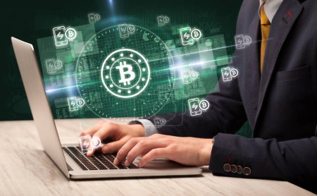 Photo for Business hand working in stock market with bitcoin icons coming out from laptop screen - Royalty Free Image