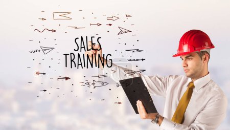 Photo for Handsome businessman with helmet drawing SALES TRAINING inscription, contruction sale concept - Royalty Free Image