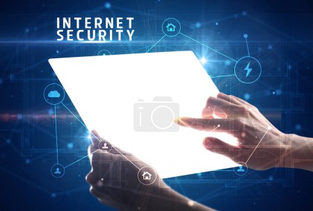 Téléchargez les photos : Tenir une tablette futuriste avec inscription INTERNET SECURITY, concept de cybersécurité - en image libre de droit