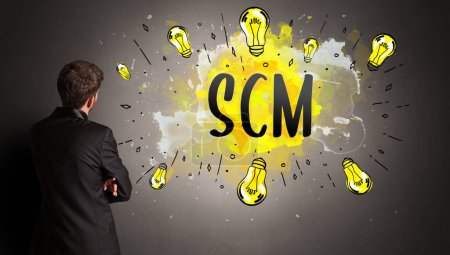 Photo for Businessman drawing colorful light bulb with SCM abbreviation, new technology idea concept - Royalty Free Image