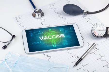 Foto de Tablet PC y herramientas médicas con inscripción VACCINE, concepto de coronavirus - Imagen libre de derechos