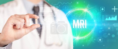Photo for Close-up of a doctor giving you a pill with MRI abbreviation, virology concept - Royalty Free Image