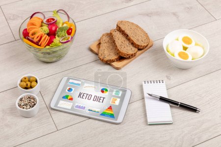 Foto de Alimento orgánico y tableta pc que muestra la inscripción KETO DIET, composición nutricional saludable - Imagen libre de derechos