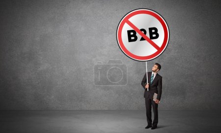Téléchargez les photos : Jeune homme d'affaires holdig panneau de signalisation avec abréviation B2B, concept de solution technologique - en image libre de droit