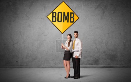 Photo for Young business person holding road sign with BOMB inscription, new rules concept - Royalty Free Image