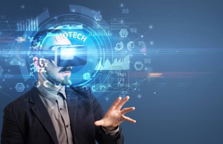 Téléchargez les photos : Homme d'affaires regardant à travers des lunettes de réalité virtuelle avec inscription BIOTECH, concept technologique innovant - en image libre de droit