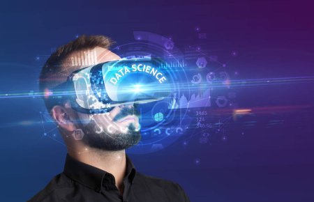 Téléchargez les photos : Homme d'affaires regardant à travers des lunettes de réalité virtuelle avec inscription DATA SCIENCE, concept technologique innovant - en image libre de droit