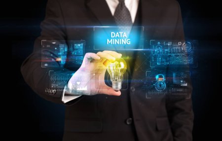 Foto de Empresario sosteniendo bombilla con inscripción de minería de datos, concepto de idea de seguridad en línea - Imagen libre de derechos