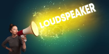 Photo for Young woman yelling to loudspeaker with LOUDSPEAKER inscription, modern media concept - Royalty Free Image