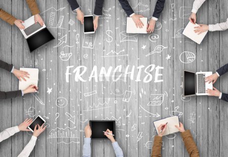 Foto de Grupo de empresarios que trabajan en la oficina con inscripción FRANCHISE, concepto de coworking - Imagen libre de derechos