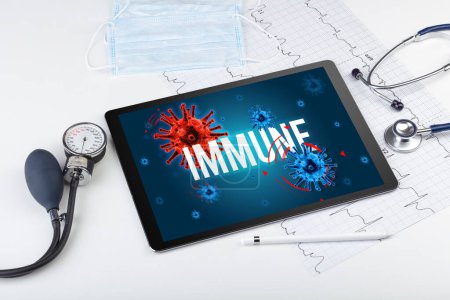 Foto de Tablet PC y herramientas médicas en superficie blanca con inscripción INMUNE, concepto pandémico - Imagen libre de derechos