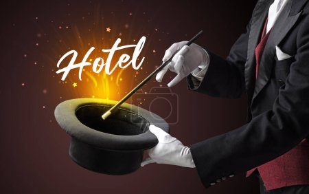 Foto de Mago está mostrando truco de magia con la inscripción del hotel, concepto de viaje - Imagen libre de derechos