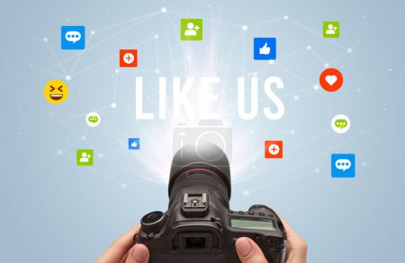 Téléchargez les photos : Utilisation de la caméra pour capturer du contenu de médias sociaux avec l'inscription LIKE US, concept de contenu de médias sociaux - en image libre de droit