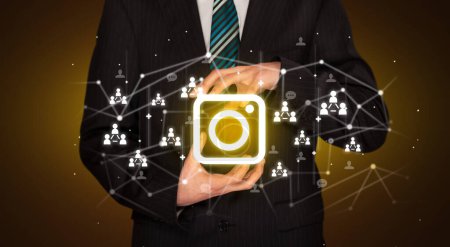 Téléchargez les photos : Main Holdig icône de la caméra autour de ses mains, Concept de réseautage social - en image libre de droit