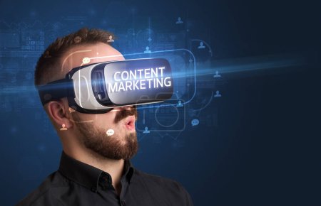 Foto de Hombre de negocios mirando a través de gafas de realidad virtual con inscripción CONTENIDO MARKETING, concepto de redes sociales - Imagen libre de derechos