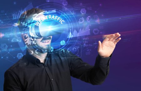 Photo for Businessman looking through Virtual Reality glasses with WEB TRAFFIC inscription, innovative technology concept - Royalty Free Image