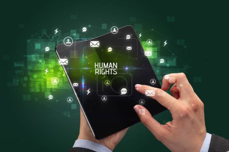 Téléchargez les photos : Homme d'affaires tenant un smartphone pliable avec inscription DROITS HUMAINS, concept de réseautage social - en image libre de droit