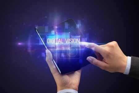 Foto de Empresario sosteniendo un smartphone plegable con inscripción DIGITAL VISION, concepto de nueva tecnología - Imagen libre de derechos