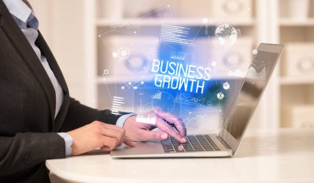 Photo for Side view of a business person working on laptop with BUSINESS GROWTH inscription, modern business concept - Royalty Free Image