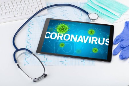 Foto de Vista de cerca de una tableta PC con inscripción CORONAVIRUS, concepto de microbiología - Imagen libre de derechos