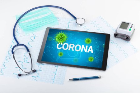Foto de Vista de cerca de una tableta PC con inscripción CORONA, concepto de microbiología - Imagen libre de derechos