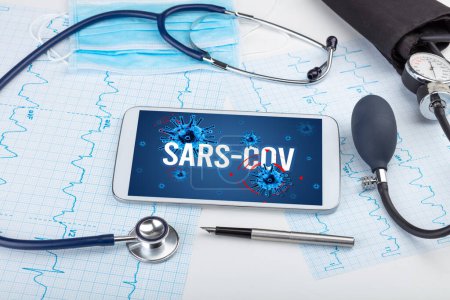 Foto de Tablet PC y herramientas médicas en superficie blanca con inscripción SARS-CoV, concepto pandémico - Imagen libre de derechos