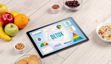 Foto de Alimento orgánico y tableta pc que muestra la inscripción DETOX, composición de nutrición saludable - Imagen libre de derechos