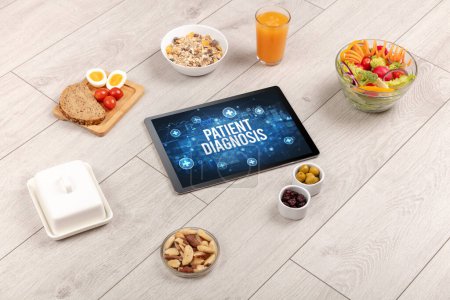 Foto de DIAGNÓSTICO DE PACIENTES concepto en la tableta PC con alimentos saludables alrededor, vista superior - Imagen libre de derechos