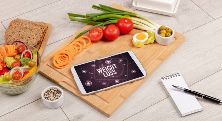 Photo for WEIGHT LOSS concept in tablet pc with healthy food around, top view - Royalty Free Image