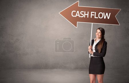 Photo for Young business person in casual holding road sign with CASH FLOW inscription, business direction concept - Royalty Free Image