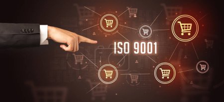 Photo for Close-Up of cropped hand pointing at ISO 9001 inscription, online shopping concept - Royalty Free Image