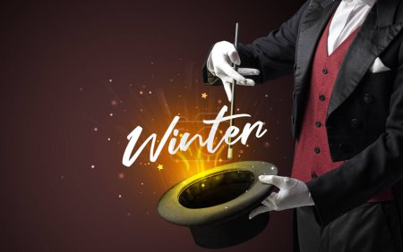 Téléchargez les photos : Magicien montre tour de magie avec inscription d'hiver, concept de voyage - en image libre de droit