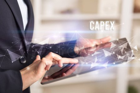 Foto de Cierre las manos utilizando tableta con inscripción CAPEX, concepto de tecnología empresarial moderna - Imagen libre de derechos