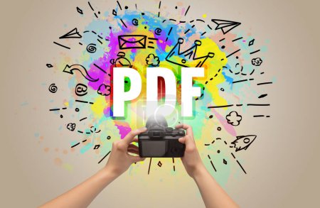 Téléchargez les photos : Gros plan d'un appareil photo numérique à main avec dessin abstrait et inscription PDF - en image libre de droit
