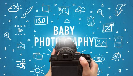 Photo for Hand taking picture with digital camera and BABY PHOTOGRAPHY inscription, camera settings concept - Royalty Free Image