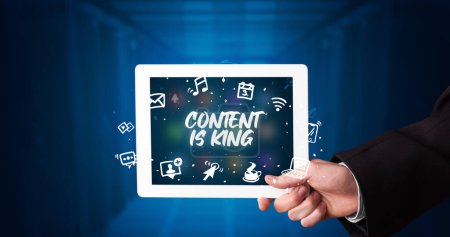 Photo for Young business person working on tablet and shows the inscription: CONTENT IS KING - Royalty Free Image