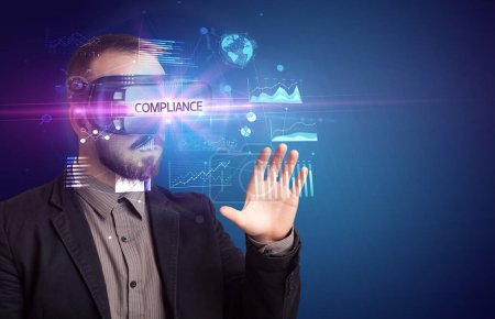 Foto de Empresario mirando a través de gafas de Realidad Virtual con inscripción CUMPLIMIENTO, nuevo concepto de negocio - Imagen libre de derechos