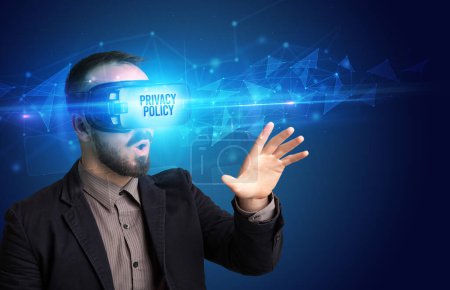 Foto de Hombre de negocios mirando a través de gafas de realidad virtual con inscripción POLÍTICA DE PRIVACIDAD, concepto de seguridad cibernética - Imagen libre de derechos