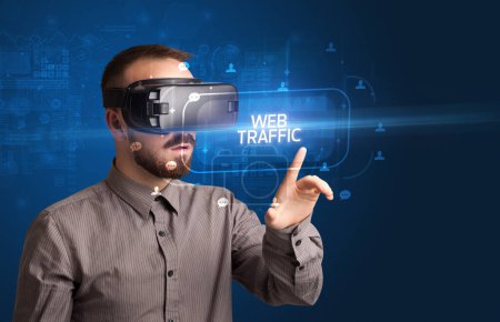 Téléchargez les photos : Homme d'affaires regardant à travers des lunettes de réalité virtuelle avec inscription WEB TRAFFIC, concept de réseautage social - en image libre de droit