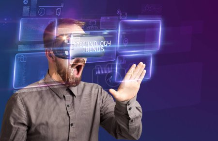 Foto de Hombre de negocios mirando a través de gafas de realidad virtual con inscripción TECNOLOGY TRENDS, concepto de nueva tecnología - Imagen libre de derechos
