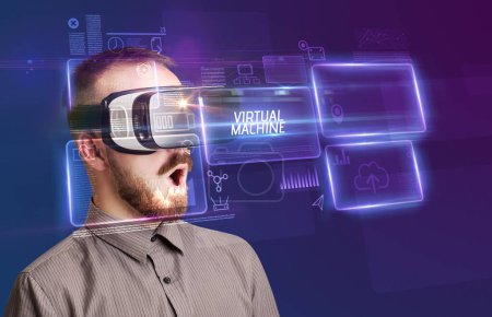 Téléchargez les photos : Homme d'affaires regardant à travers des lunettes de réalité virtuelle avec inscription VIRTUAL MACHINE, nouveau concept technologique - en image libre de droit